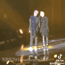 two men standing on a stage with sbs 2016 unicorn501 written on the bottom