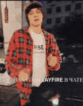 a man wearing a plaid shirt and a white shirt that says rbe is dancing