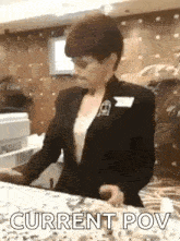 a woman in a suit is standing at a counter in a hotel .