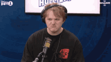 a man wearing headphones and a siriusxm logo behind him