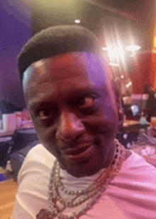 a man wearing a necklace is making a funny face .