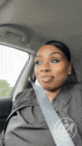 a woman wearing a seat belt in a car with a logo for audience