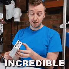 a man in a blue shirt is holding a box with the word incredible on it