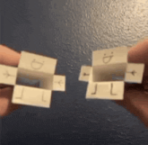 a person is holding two pieces of paper with the letters d and l written on them .