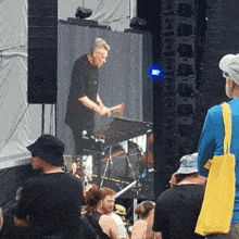 a man playing a keyboard in front of a crowd of people