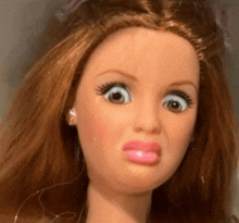 a close up of a barbie doll 's face with a surprised look on her face .