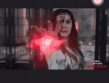 a close up of a woman 's hand with a red light coming out of it