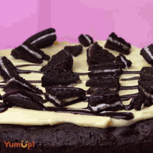 a cake with oreos on top and the words yum up on the bottom right