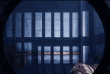 a prison cell with bars and a light coming through them