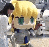 a woman talking into a microphone next to a stuffed toy