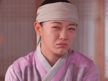 a woman with a bandage on her head is making a face