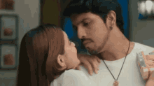 a man and a woman are kissing each other .