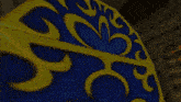 a blue and yellow item with a swirl design on it