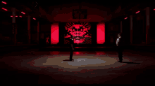 a man in a white shirt and black vest is standing in front of a red background with a dragon on it .
