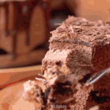 a piece of chocolate cake is being eaten with a fork and the word mr.cakes is visible in the corner