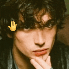 a close up of a man 's face with a hand sticker on his forehead .