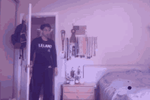 a man in a leland shirt stands in front of a door