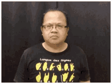 a man wearing a black shirt that says langue des signes on it
