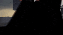 a cartoon character is holding a gun in his hand and walking in the dark .
