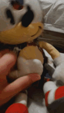 a person is holding a stuffed animal that looks like donald duck