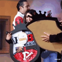 a woman is holding a framed picture with the letter p on it