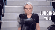 a woman wearing boxing gloves is sitting on a set of stairs and making a funny face .