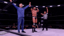 a man in a wrestling ring with a sign that says aew