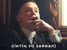 a man in a suit and tie is smoking a cigar with a caption in another language