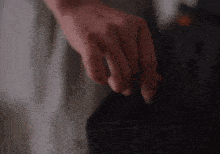 a close up of a person 's hand reaching into a box .