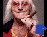 a man with glasses is smoking a cigar and holding a blue shirt with the letter g on it