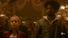 a man and a woman are standing in a dark room with the words mill turning girl visible