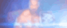 a blurry picture of a muscular man with a blue light coming out of his chest .