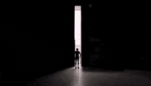 a man in a spider man costume is standing in a dark room .
