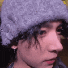 a close up of a person wearing a hat and earrings