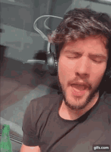a man wearing headphones and a black shirt is singing