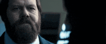 a close up of a man 's face with a mustache in a dark room