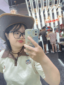 a woman taking a picture of herself in a store with a sign that says ' uoxuan ' on it