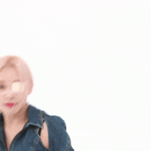a woman wearing a denim jacket and sunglasses is making a funny face .