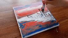 a person is using a brush to paint a painting on a canvas