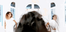 a group of women are standing around a man 's head with their hair blowing in the wind