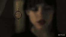 a woman wearing a necklace with the word netflix on the bottom right