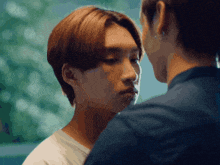 a man and a woman are touching their foreheads and looking at each other