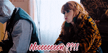 a woman in a tiger print jacket is sitting next to a man in a white shirt and vest and says nooooooon ??