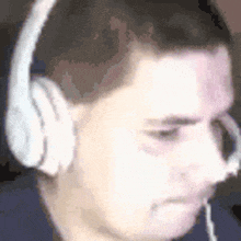 a man wearing headphones and a microphone is making a funny face .