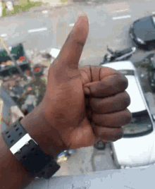 a person giving a thumbs up with a watch on their wrist