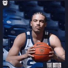 a basketball player named yame butler is holding a basketball in his hands