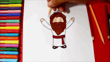 a drawing of jesus with his arms outstretched is being drawn on a piece of paper