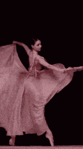 a woman in a pink dress is dancing on a black background