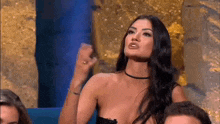 a woman in a plunging neckline is sitting in front of a group of people .