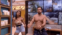 a man and a woman are dancing in a room with a picture of a coral reef on the wall .